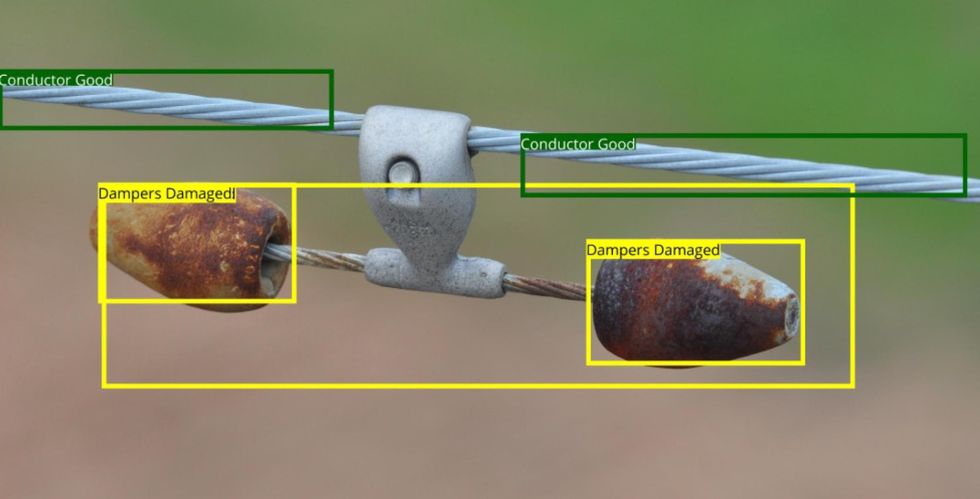 Close up of grey power cords circled in green and labelled u201cConductor Goodu201d. A silver piece hanging from it holds two conical pieces on either side, which look burned and are circled in yellow, labelled u201cDampers Damagedu201d.