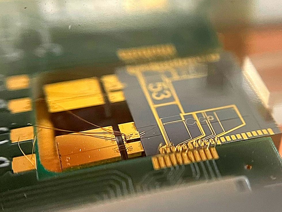 Close-up photograph of golden blocks and circuitry on a green board.
