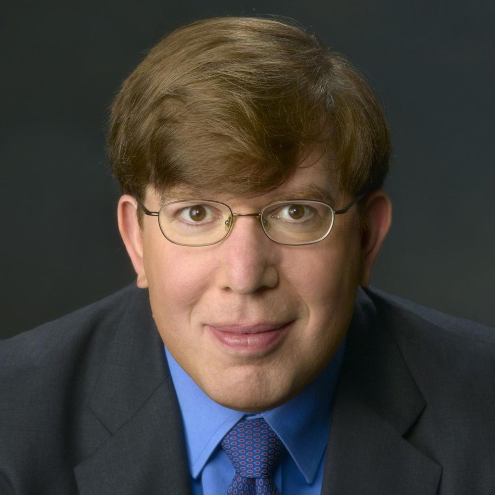 Closeup of a man wearing glasses and a suit