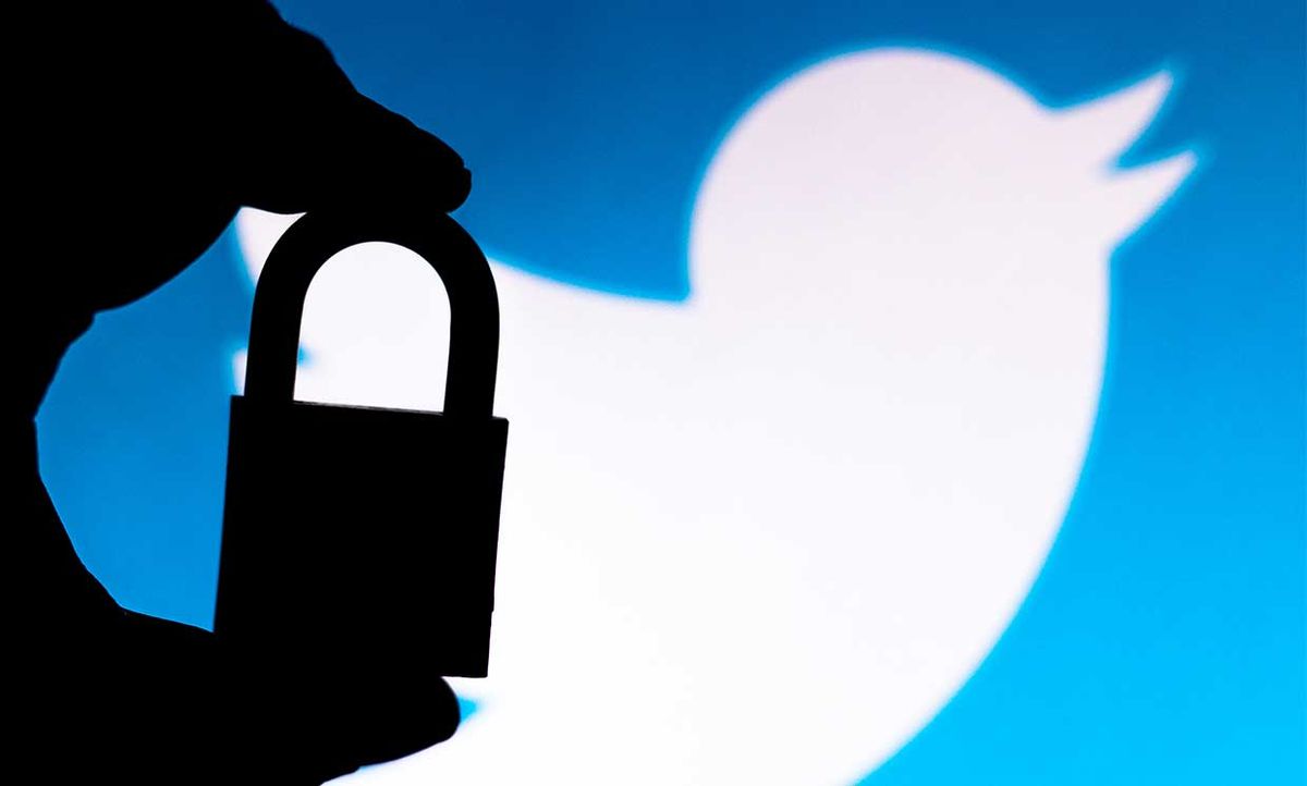 Conceptual photo of someone holding a lock in front of the Twitter logo