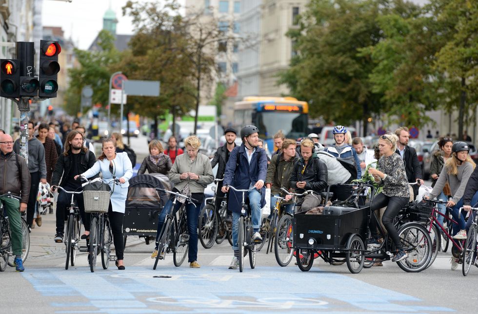 Cyclist waiting at a red light at an intersection in Copenhagen, Denmark.