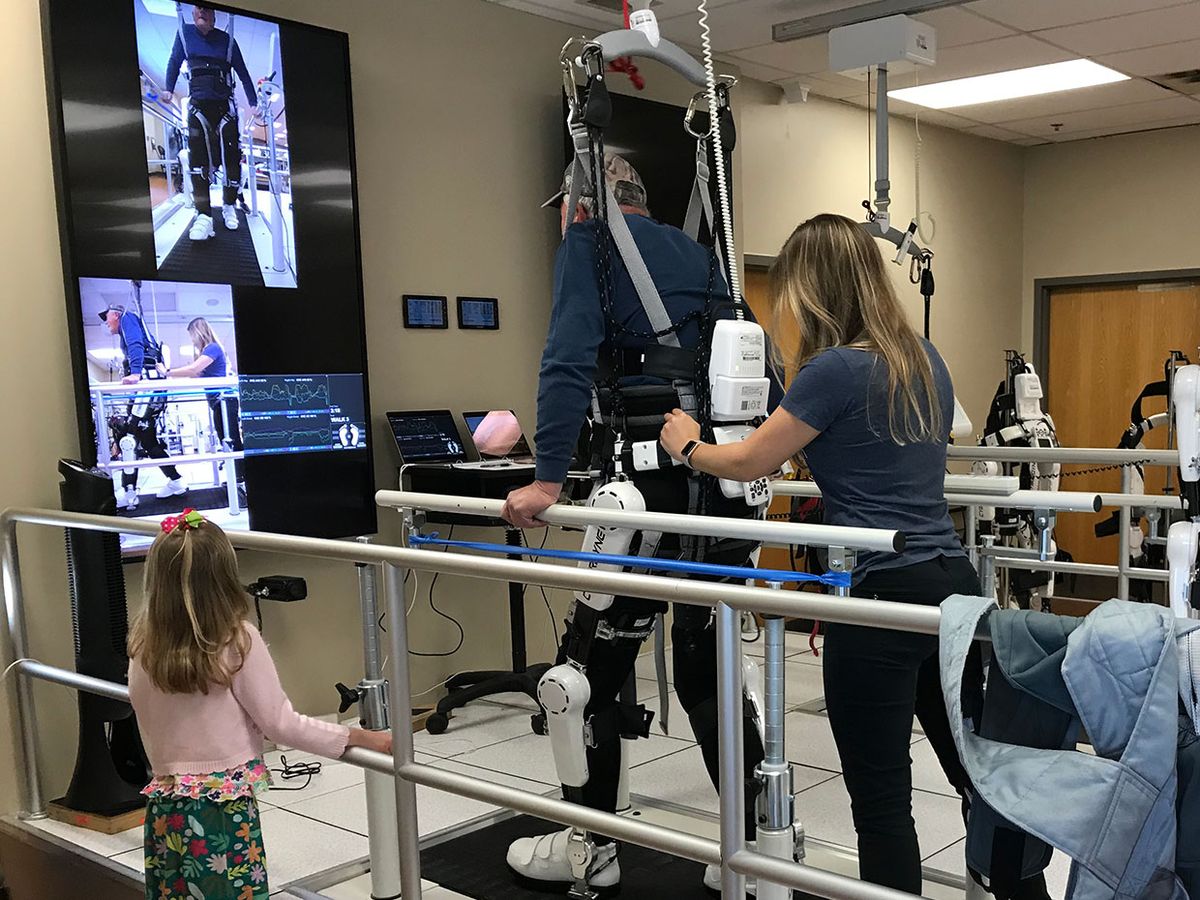 Danny Bal completes a treatment session with the Cyberdyne HAL exoskeleton at Brooks Rehabilitation in Jacksonville, Florida as his granddaughter cheers him on.