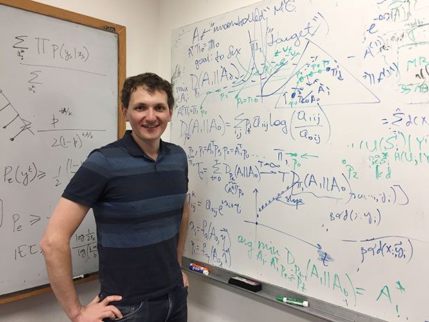 Dmitri Pavlichin poses with whiteboards he created for the real world; he also does the math for HBO's Silicon Valley