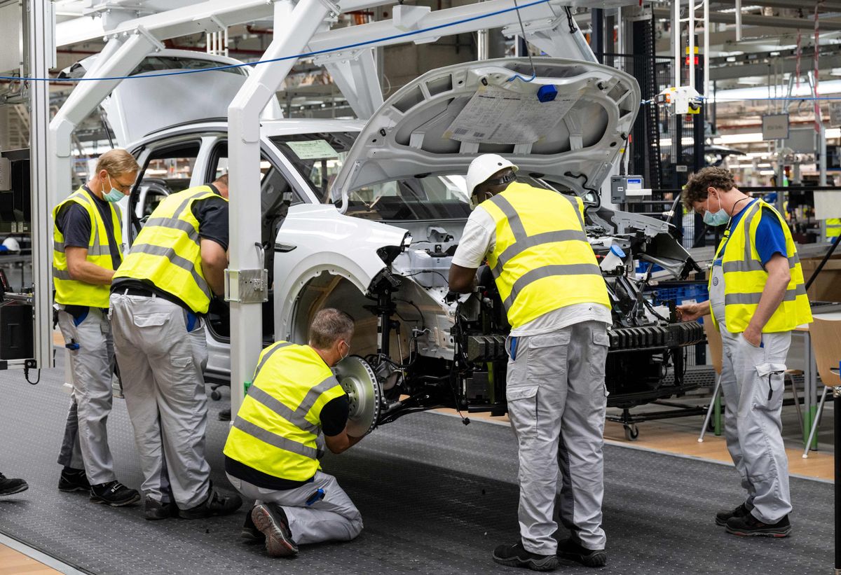 Employees work at the assembly line of the Volkswagen (VW) ID 4 electric car of German carmaker Volkswagen, in the production site of Emden, northern Germany on May 20, 2022.