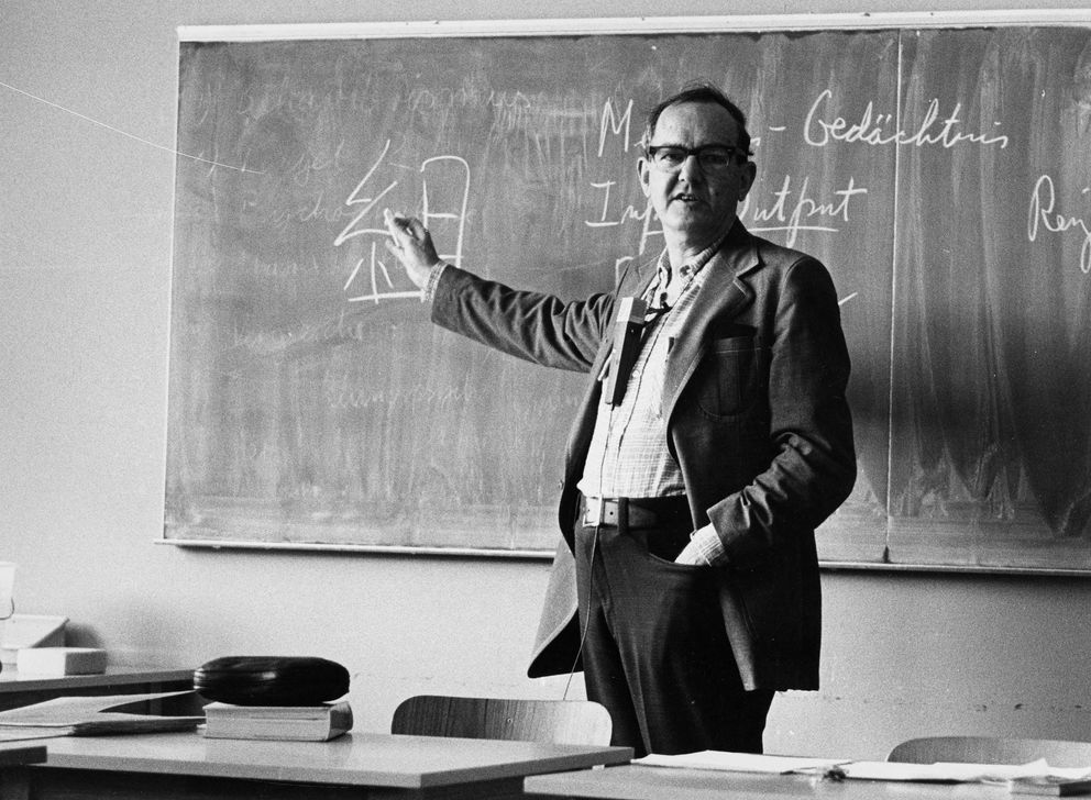 Image of Herbert Simon teaching in a classroom.