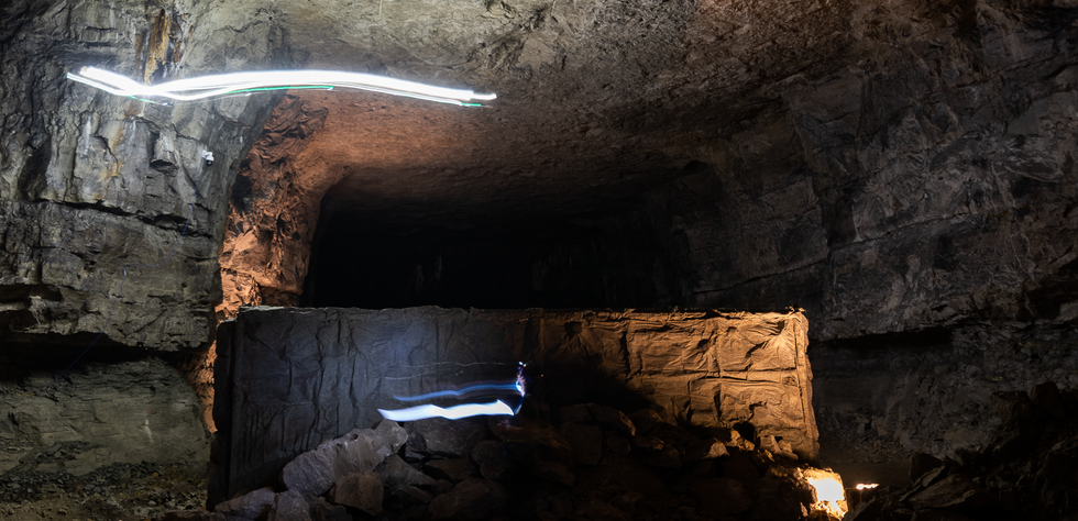 Two streaks of light illuminate a large dark cave