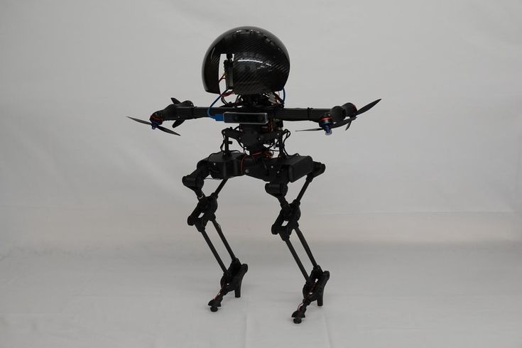 A black bipedal robot with a round head and four thrusters standing on the ground