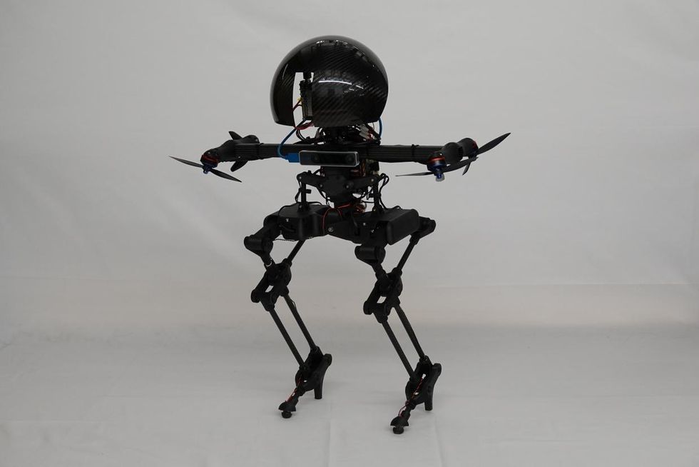 Un robot bipède noir avec une tête ronde et quatre propulseurs au sol