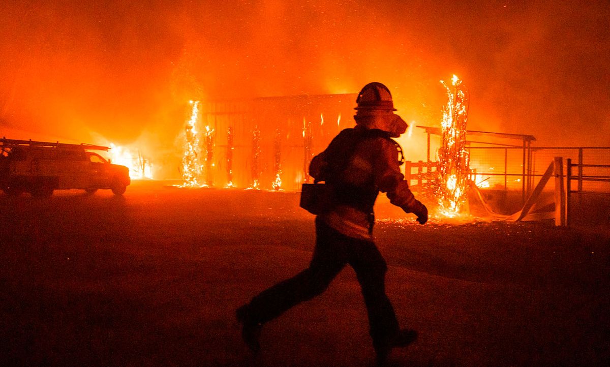 Firefighters battle to save structures on a farm in Windsor, California during October's Kincade fire, which was driven by wind but ignited by a PG&E power line.