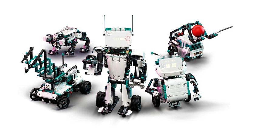 Five different LEGO robots built with black, green, and white blocks, plus wheels and a compute module, stand against a white background.