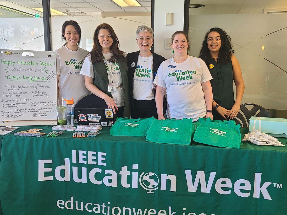 Five women standing in front of a sign that says IEEE Education Week