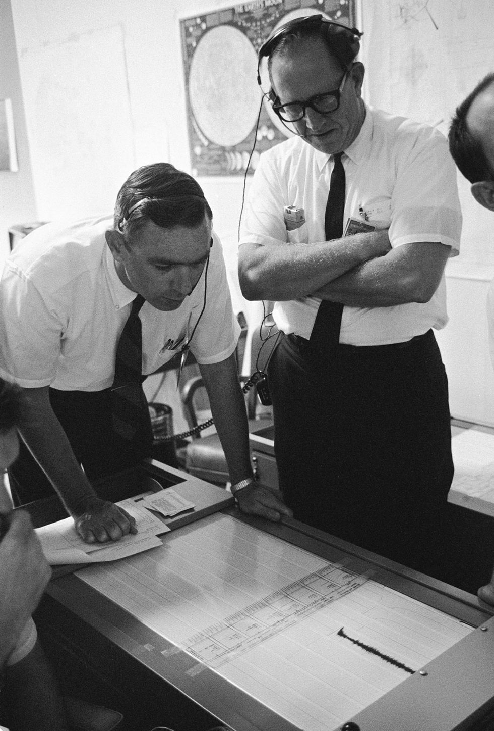 Gary Latham, left, then a seismologist at the Lamont Geological Observatory at Columbia, examines a trace measurement from the moon in 1969. The signals came digitally; scientists would then print it out and make measurements by hand.