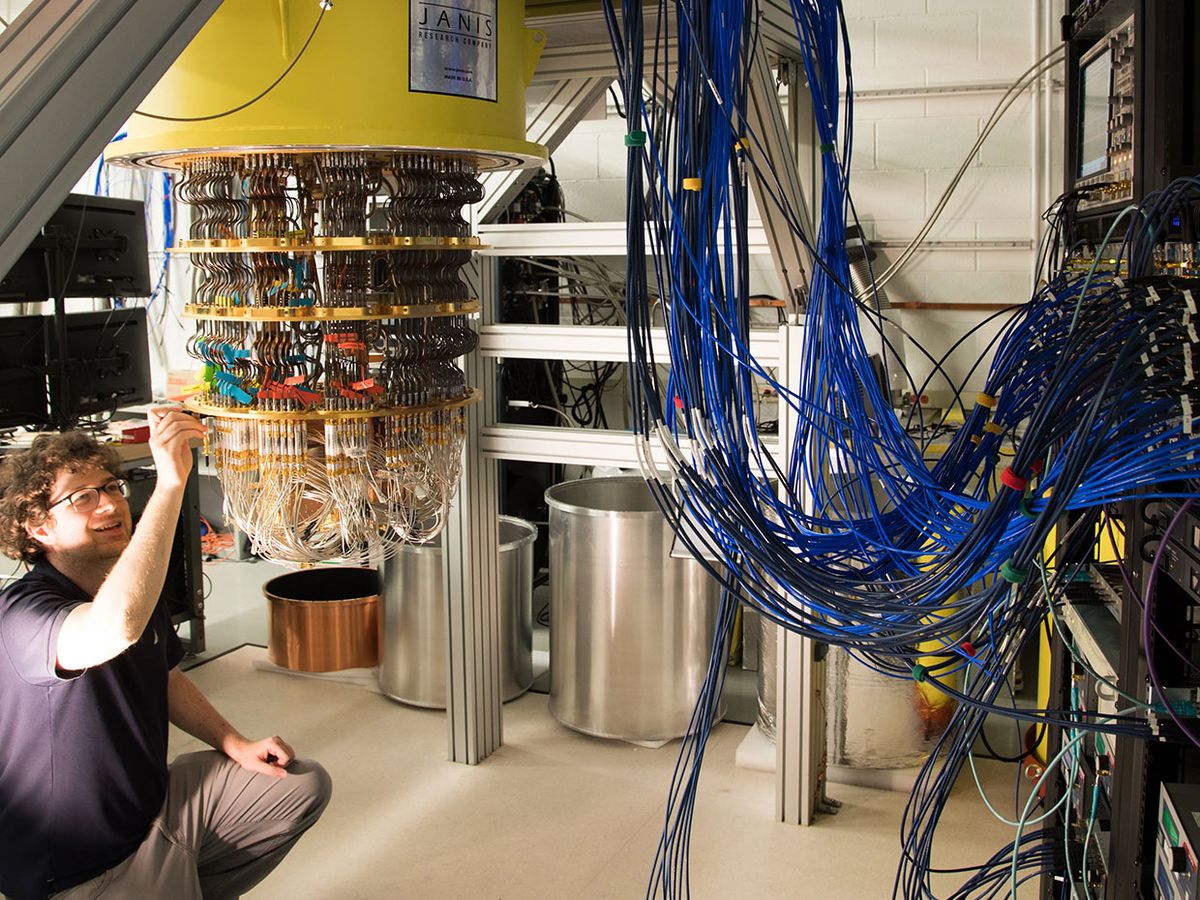 Google engineer Amit Vainsencher examines his company's quantum computer system. Even with only half the needed connections attached, there's a crowd of cables feeding into the 72-qubit quantum processor.