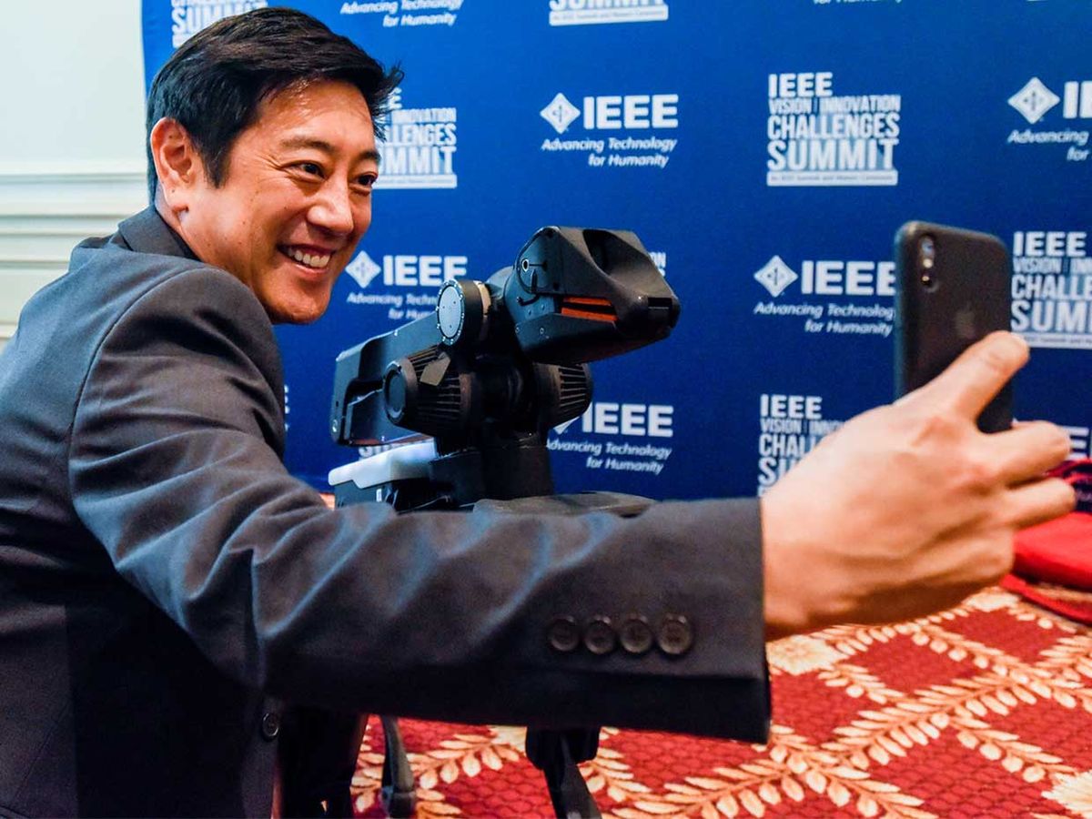 Grant Imahara takes a selfie with Boston Dynamics' SpotMini robot at the 2018 IEEE Vision, Innovation, and Challenges Summit & Honors Ceremony.