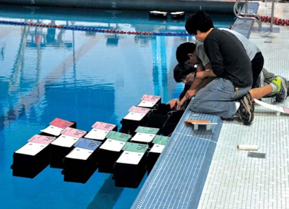 Groups of modular robotic boats form structures on water.