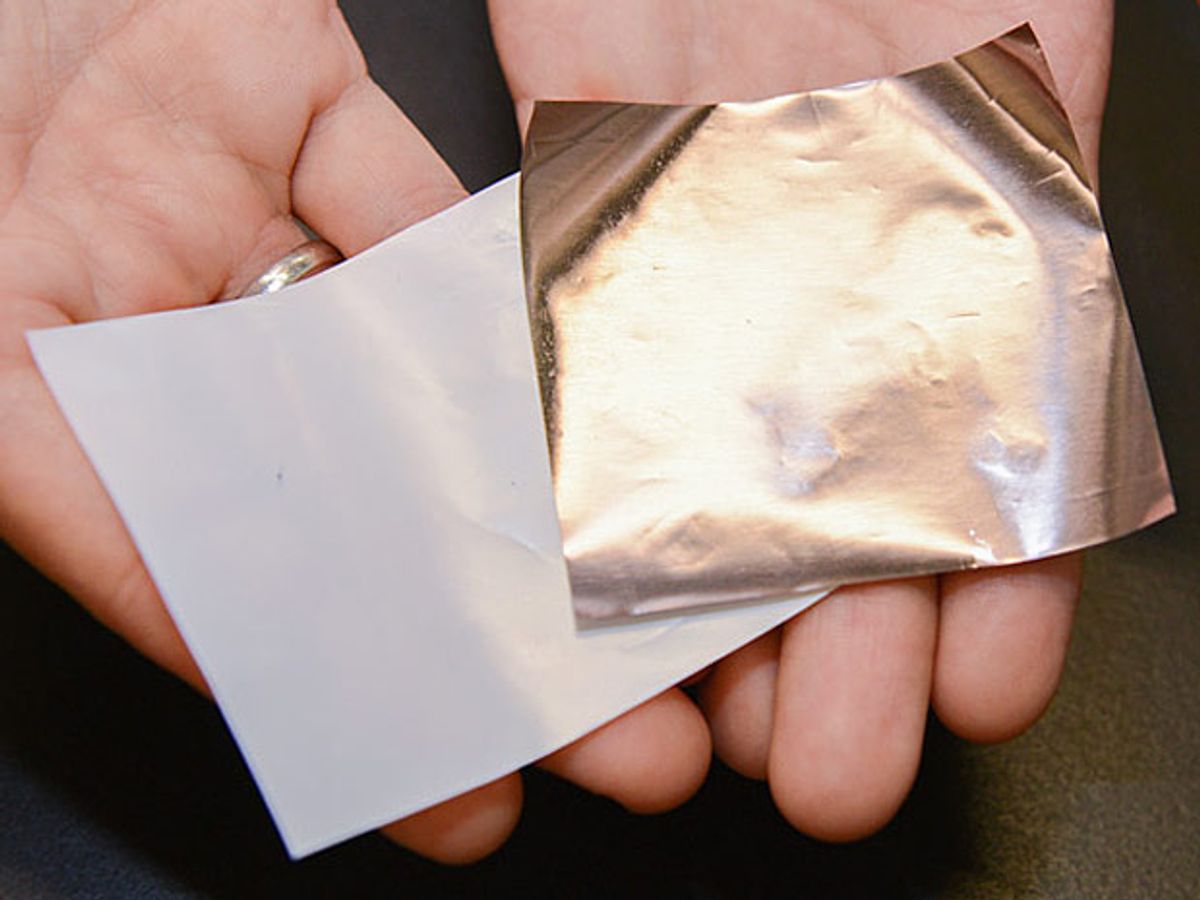 Hands holding a white square and square of copper foil