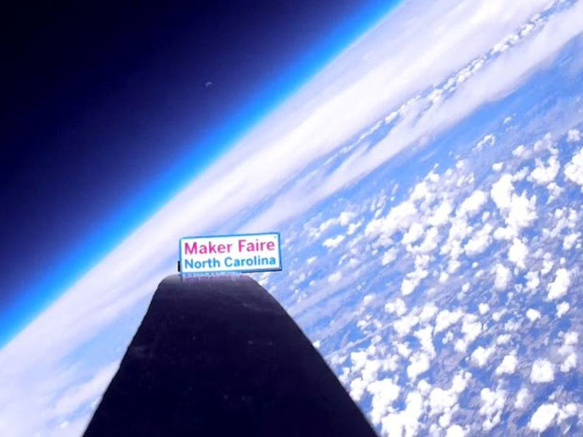 High-altitude image of Maker Faire sign with moon rising over the curved horizon 