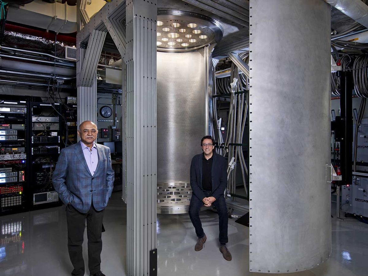 IBM CEO Arvind Krishna (left) and Director of IBM Research Dario Gil are pictured with a 10-foot-tall and 6-foot-wide “super-fridge,” a custom built dilution refrigerator larger than any commercially available.