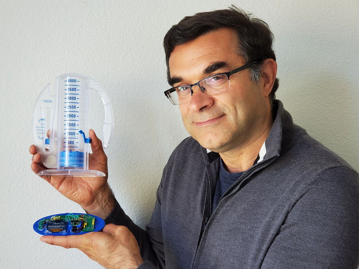 IEEE Member Farid Farahmand holds the InSee, an auxiliary device that attaches to an incentive spirometer.