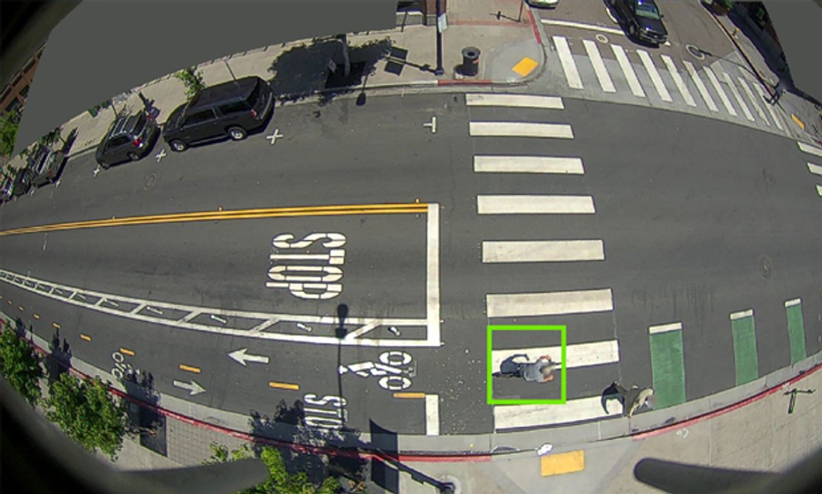 Image of a bike with a square around it next to cars on the street.