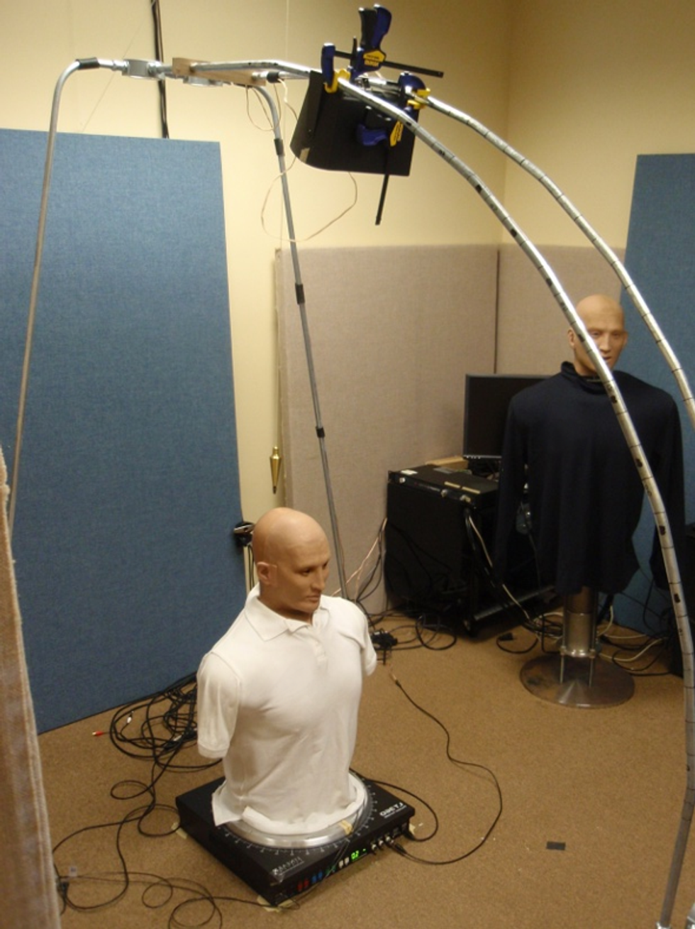 Image of a human body dummy on the floor atop a audio device.