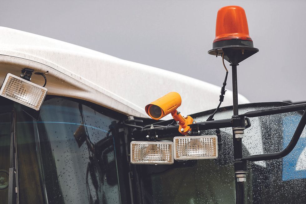 Image of a orange camera attached to a combine harvester.