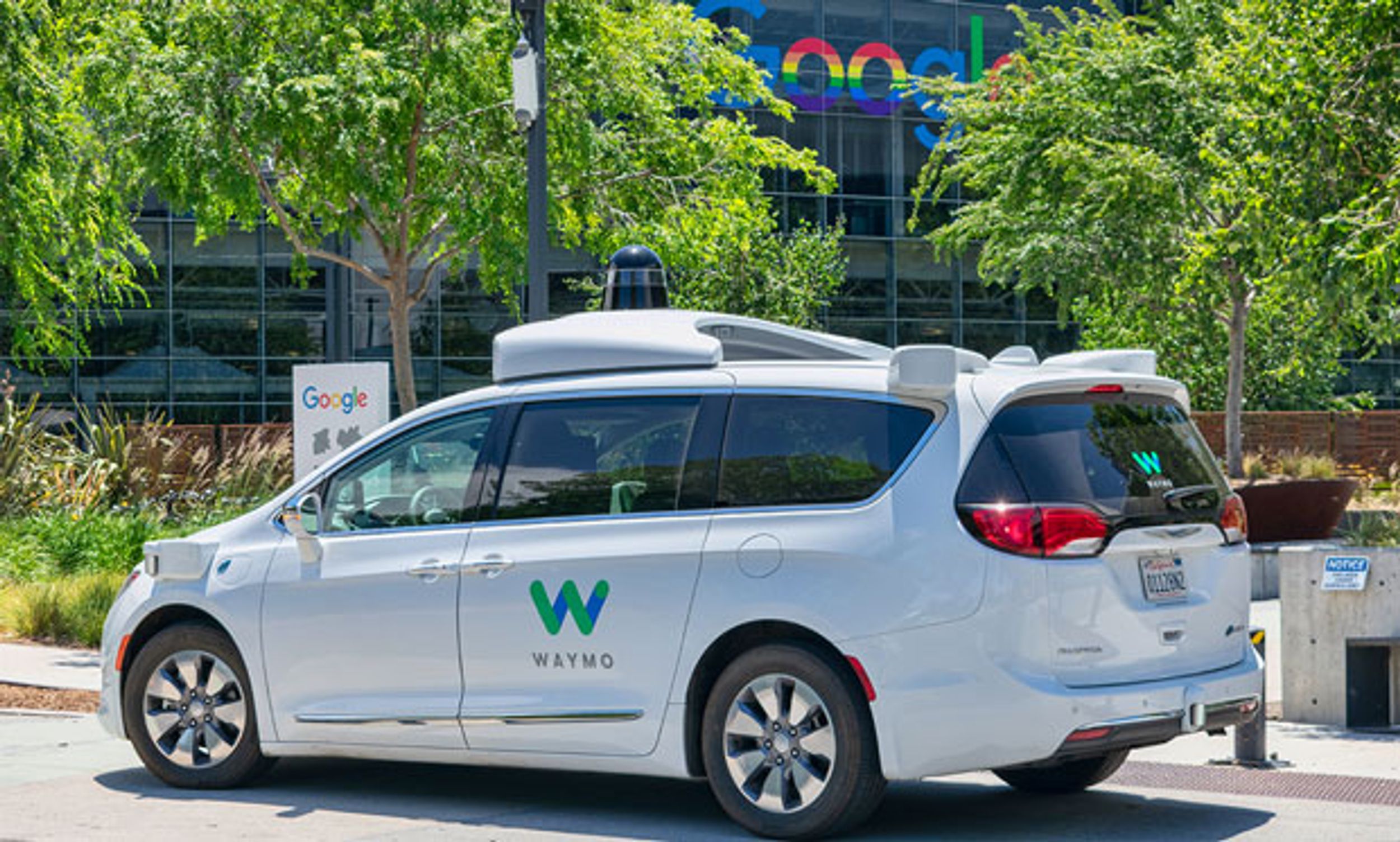 Image of a Waymo car in front of the Google sign