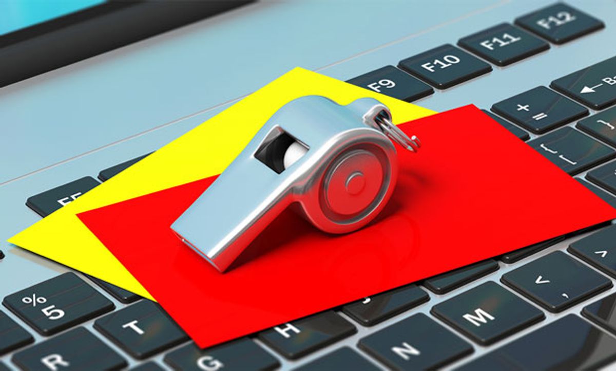 Image of a whistle paired with red and yellow cards, all on top of a laptop keyboard.