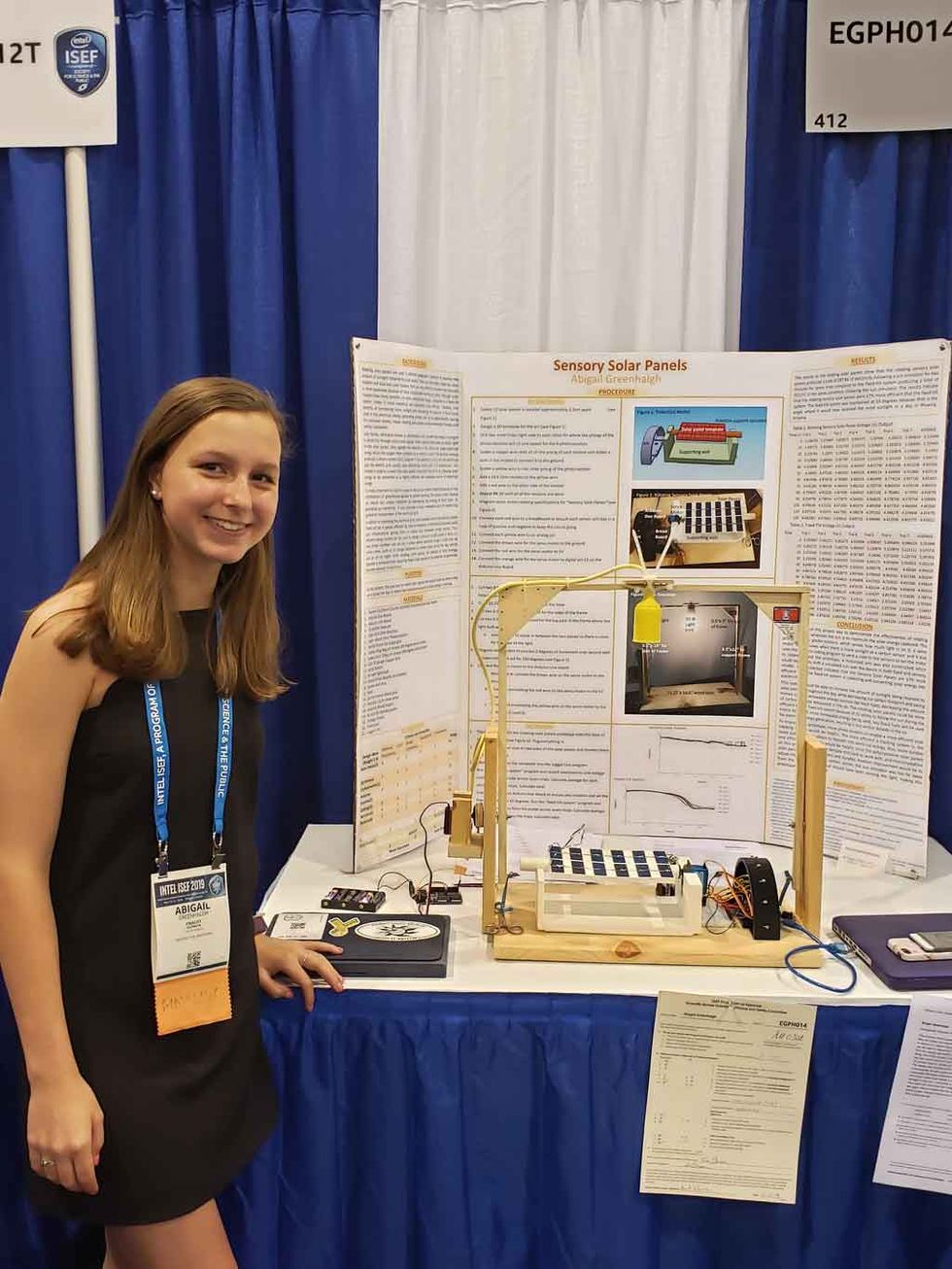 Image of Abigail Greenhalgh standing in front of her project display. 