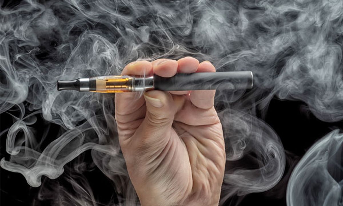 Image of an e-cigarette on a black vape-filled background.