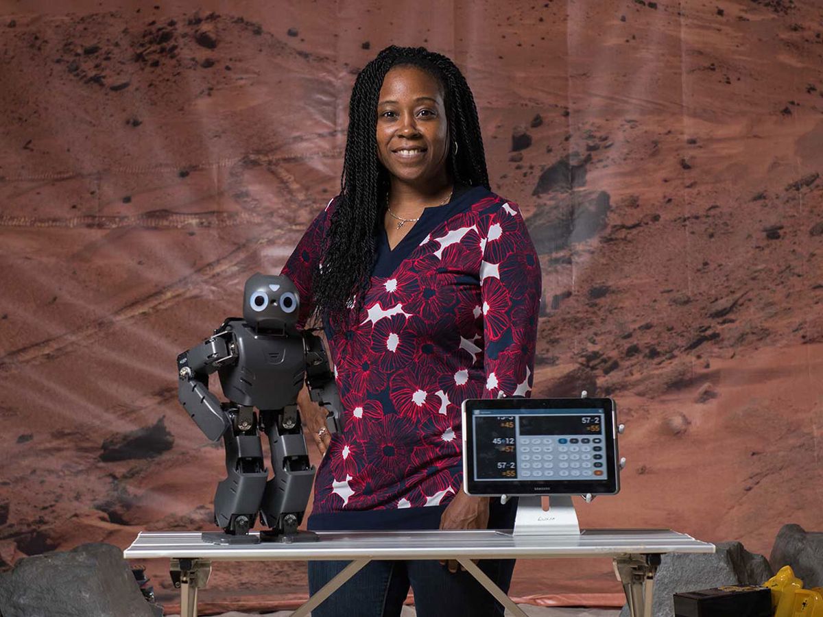 Image of Ayanna Howard smiling with a robot.