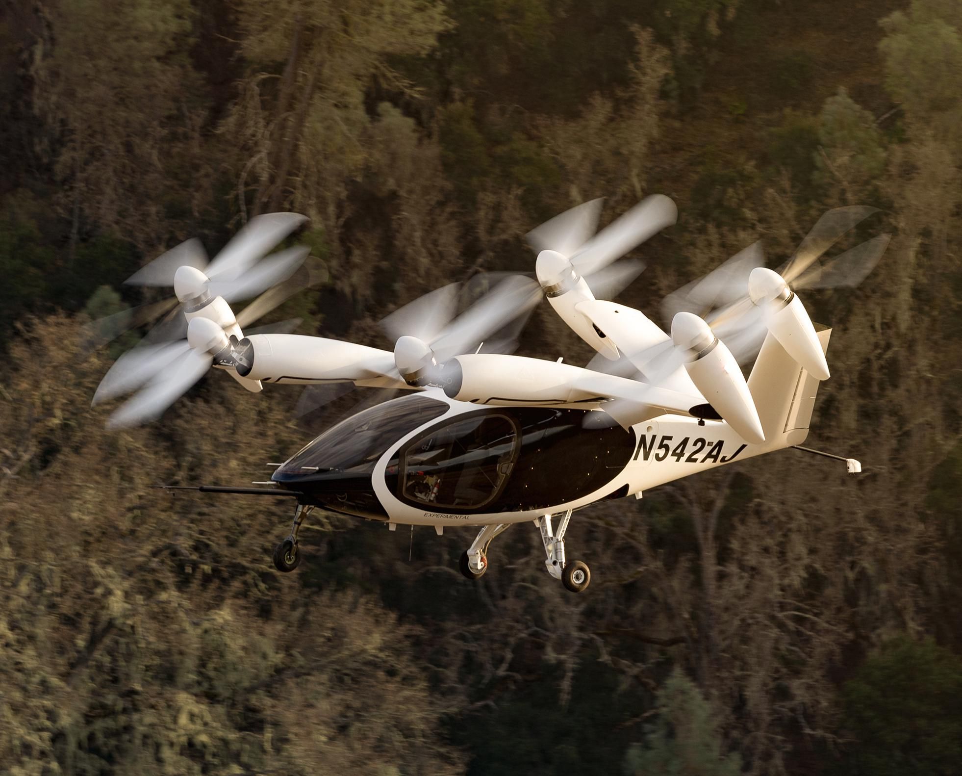 Image of Joby Aviation piloted aircraft flying above a forest.