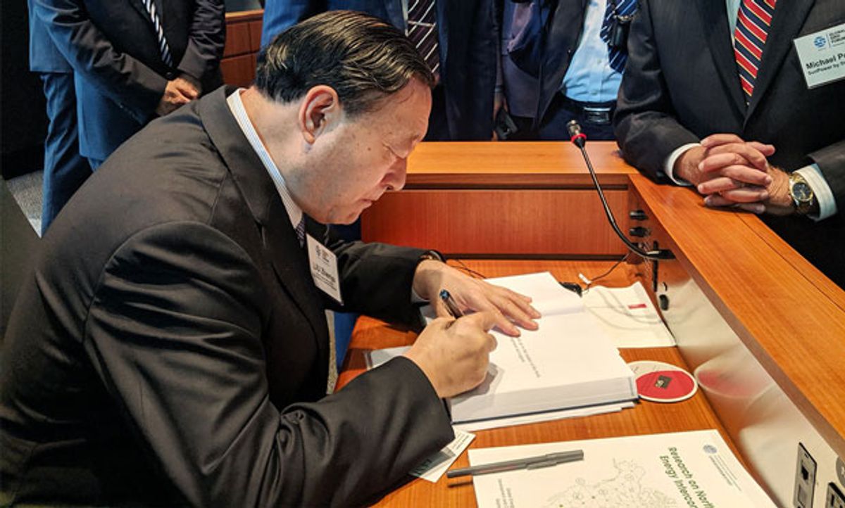 Image of Liu Zhenya signing a copy of his 2015 book, Global Energy Interconnection