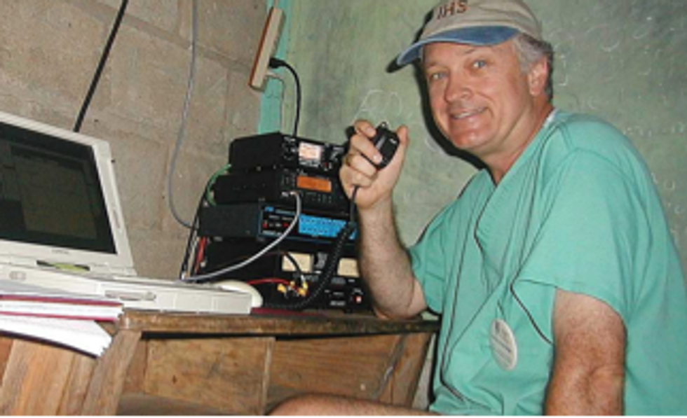 Image of Loring Kutchins holding a microphone connected to a transmitter. 