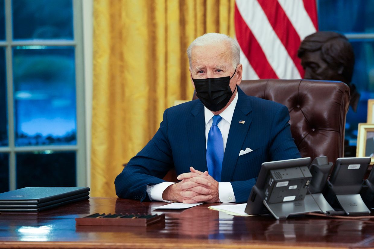Image of President Joe Biden sitting at the oval office desk.