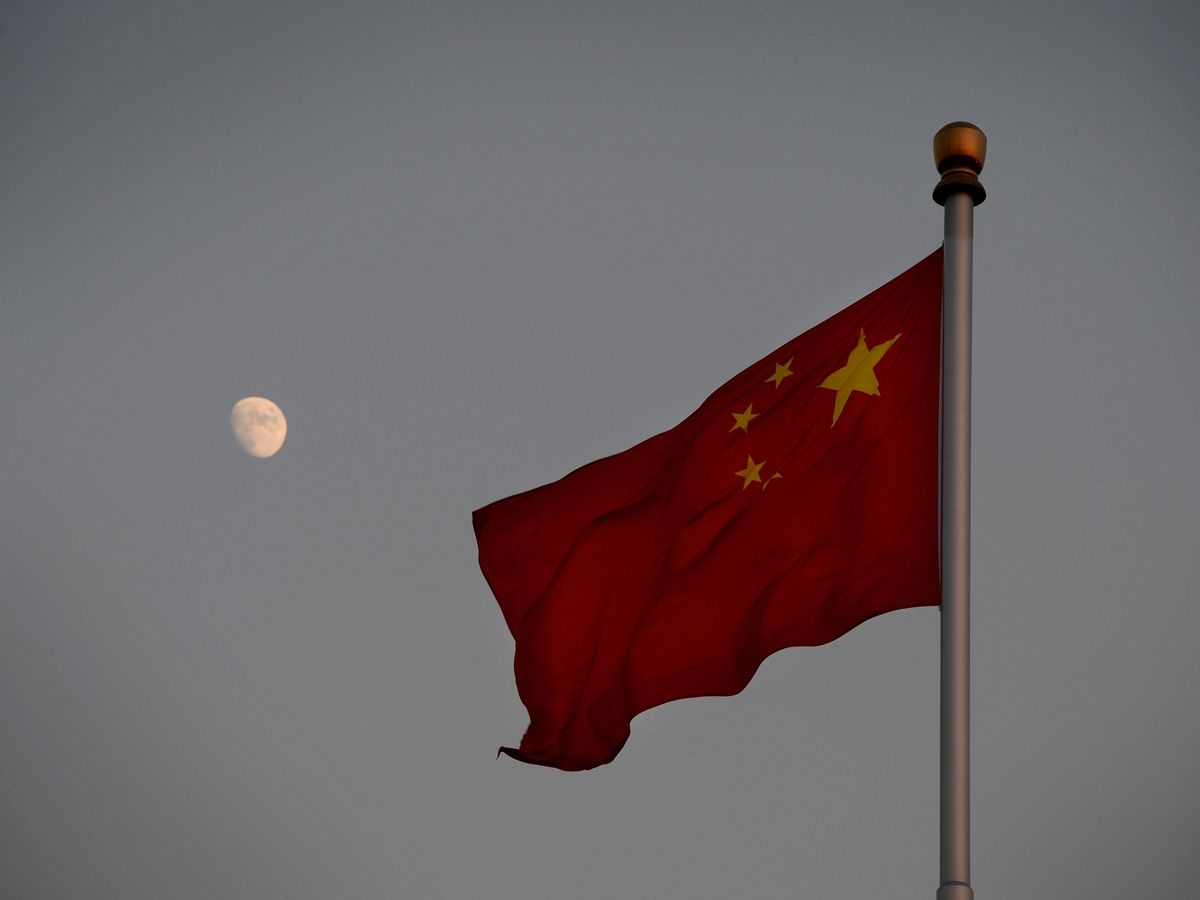 Image of the China national flash with the moon in the background.