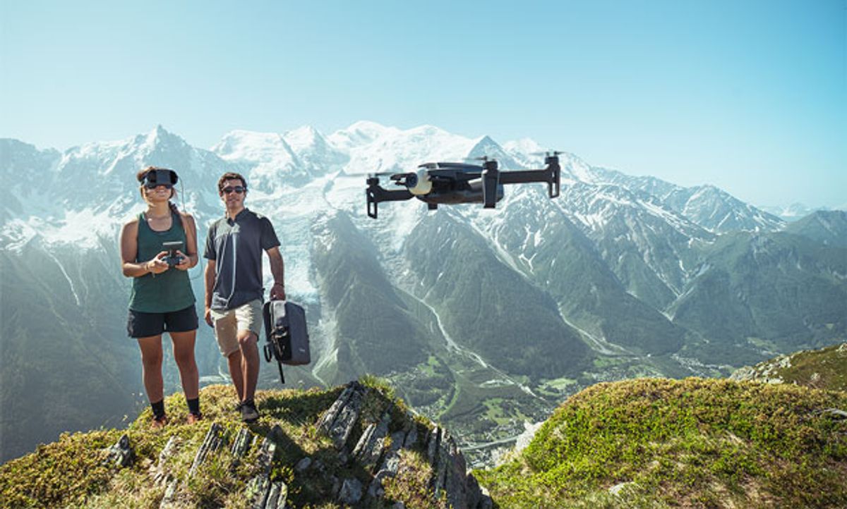 Image of two people flying the drone above a river.