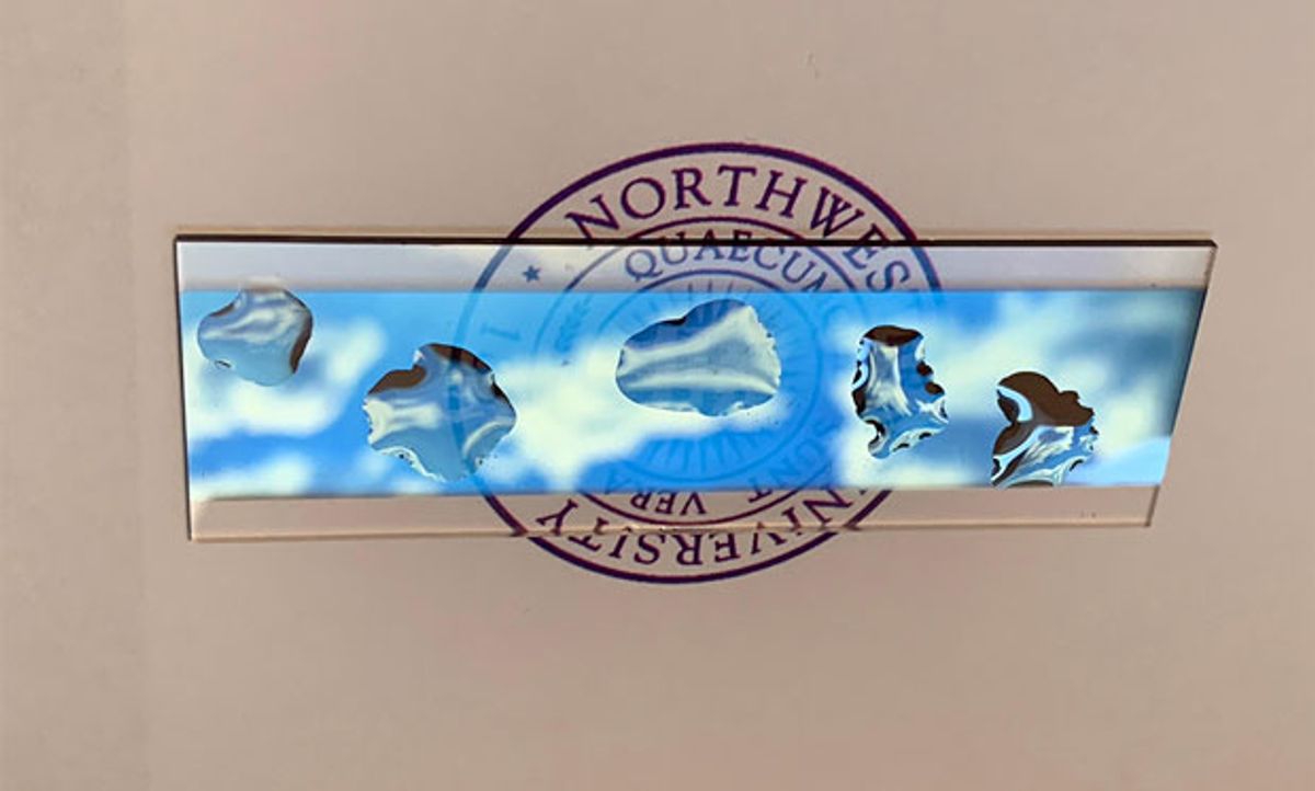 Image of water droplets on a slide with the Northwestern logo in the background.