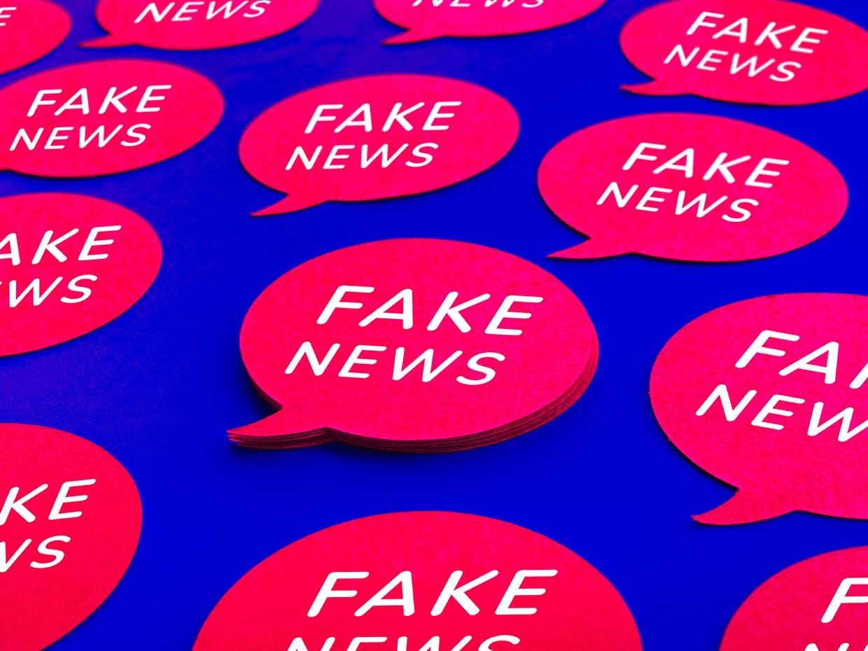 Illustration of rows of word bubbles that say "Fake News."