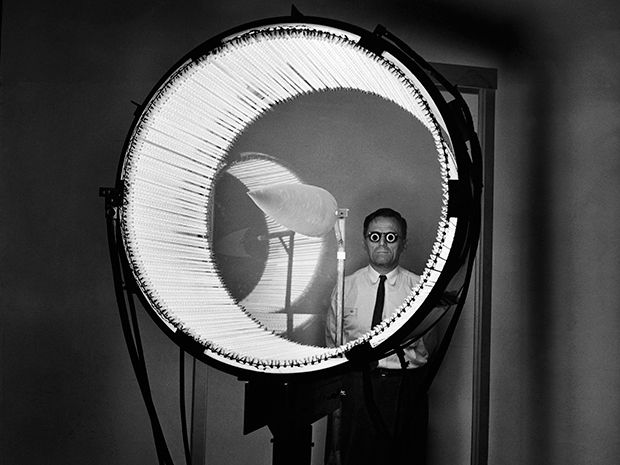 Photo of a scientist looking on as a pointed nose cone is heated to mimic reentry conditions. 