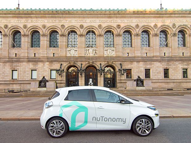 A NuTonomy self-driving taxi in front of a grand-looking building, the Boston Public Library