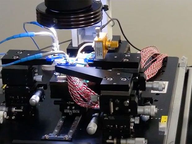A tiny terahertz transmitter is mounted under a microscope in a lab at Hiroshima University.