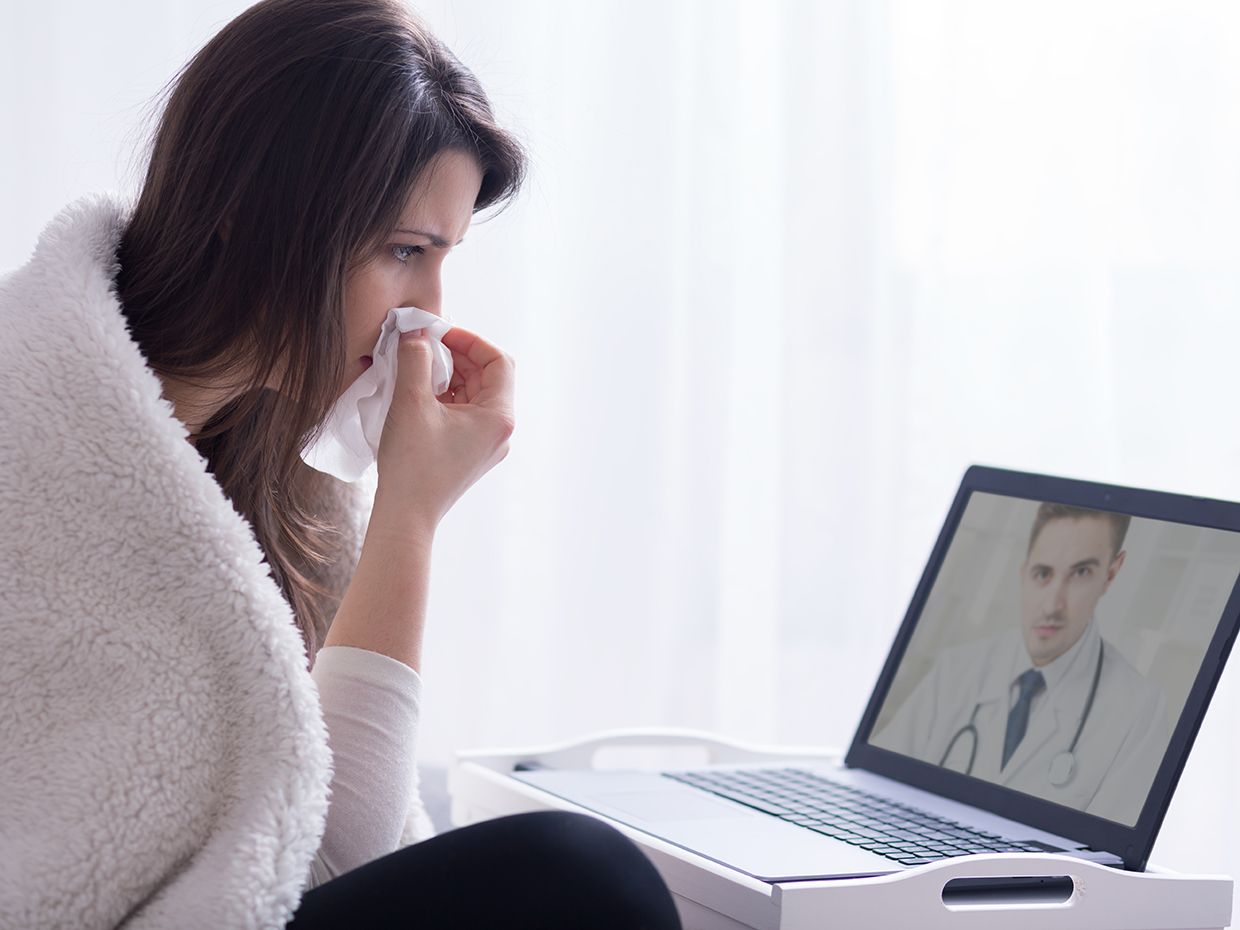 Sick women communicating with a doctor on her computer
