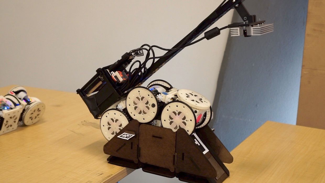 Modular robot completing tasks by deploying and crossing bridges and ramps made of building blocks