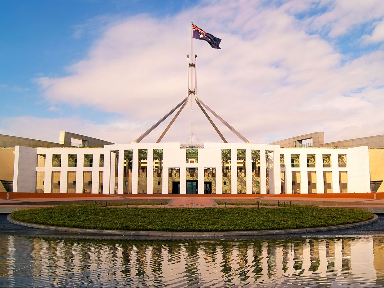 An Australian flag flies over a government building.