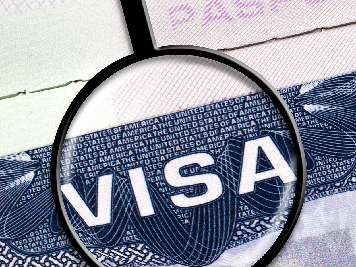 Magnifying glass over a visa.