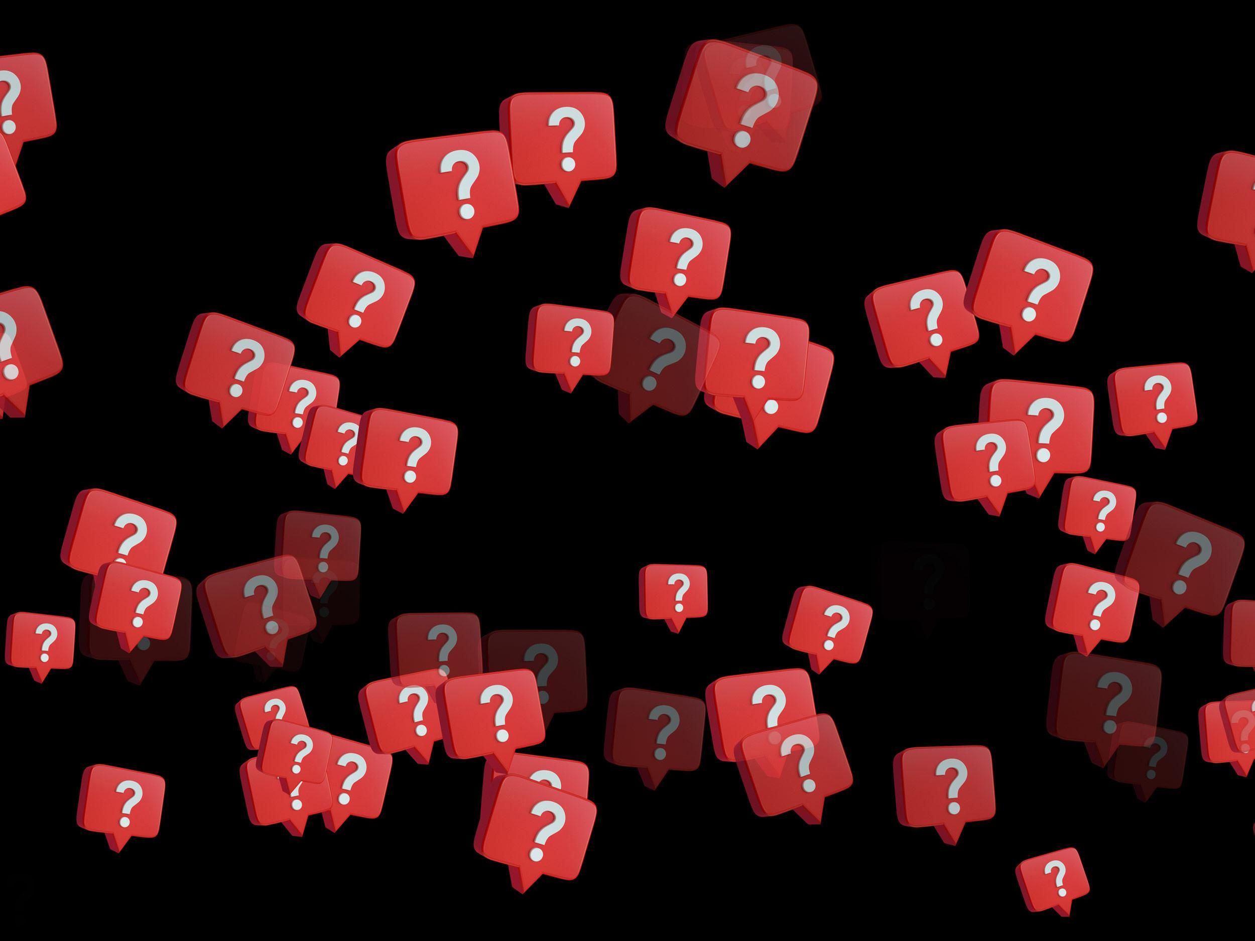 multiple red speech bubbles with question marks inside against a black background
