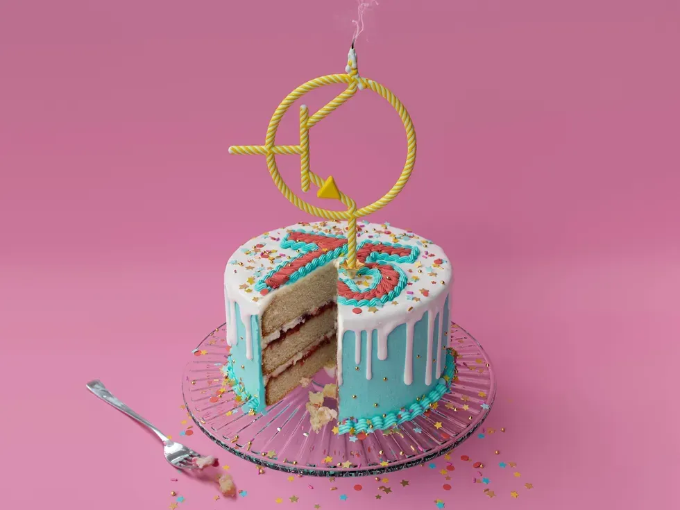 A cake with a candle in the shape of a transistor symbol. A slice has been taken out of the cake, and a fork lies next to it.