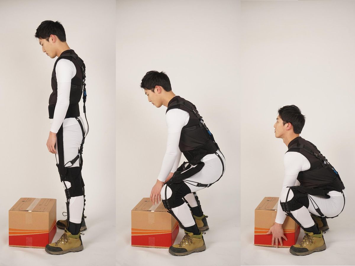 # images showing a person bending down to pick up a box while wearing the exosuit.