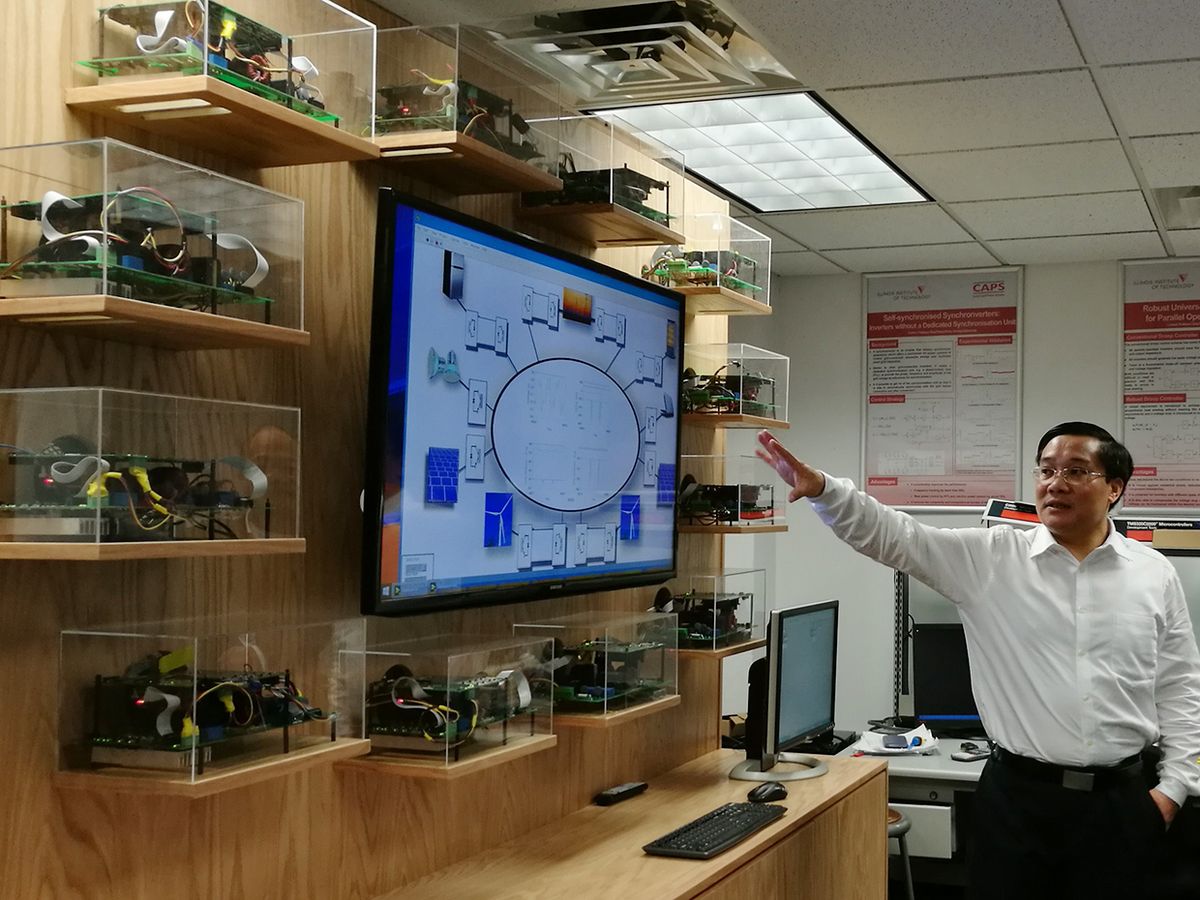 In his laboratory at the Illinois Institute of Technology, Qing-Chang Zhong points to a computer diagram of his SYNDEM concept.